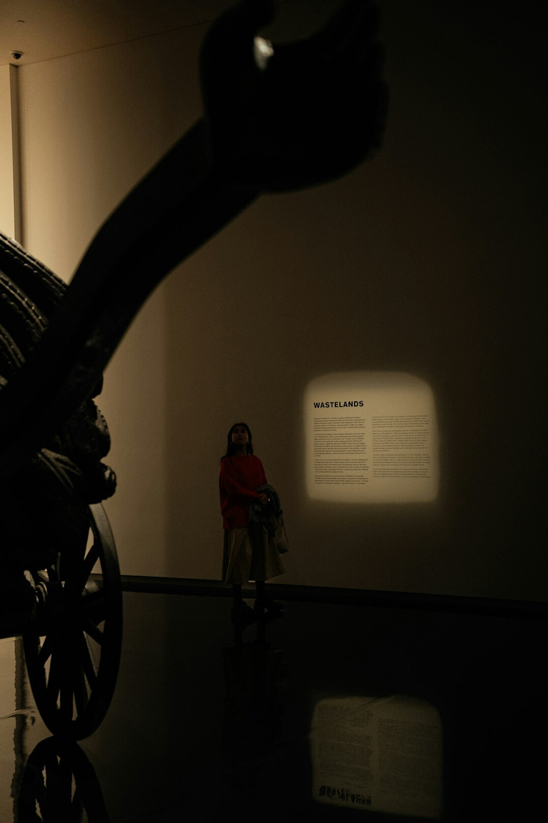 Curator arranging an exhibition display with a spotlighted car