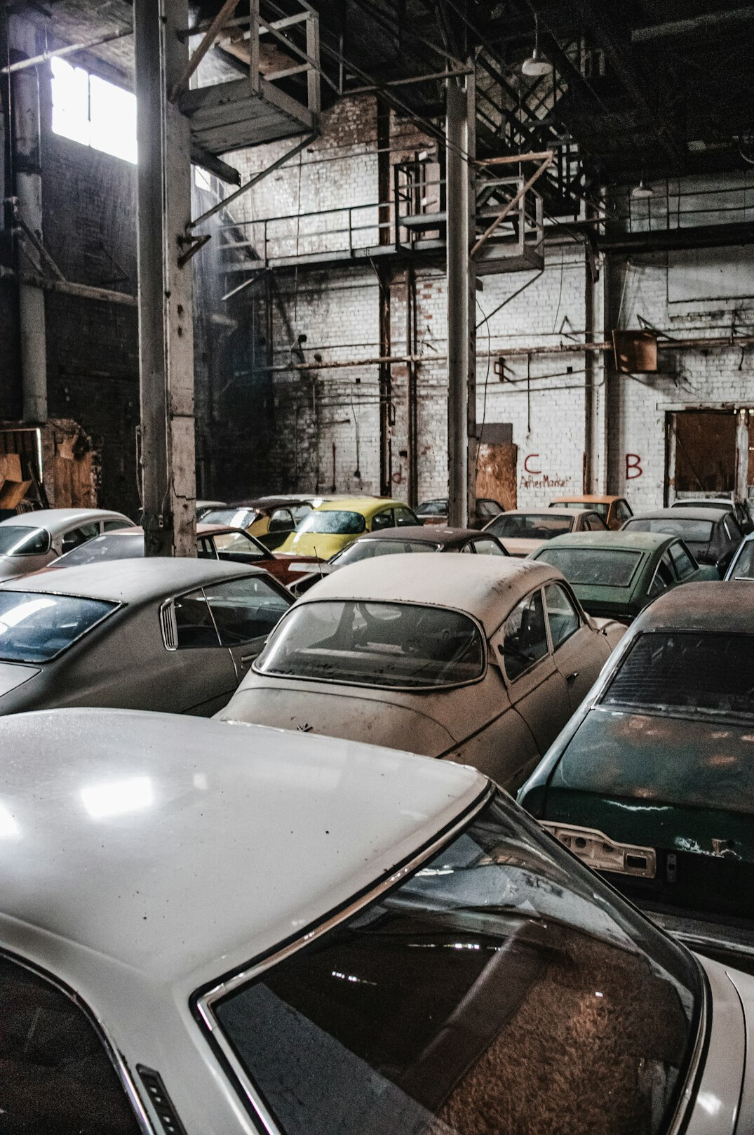 Rows of catalogued vintage cars stored in an archival warehouse
