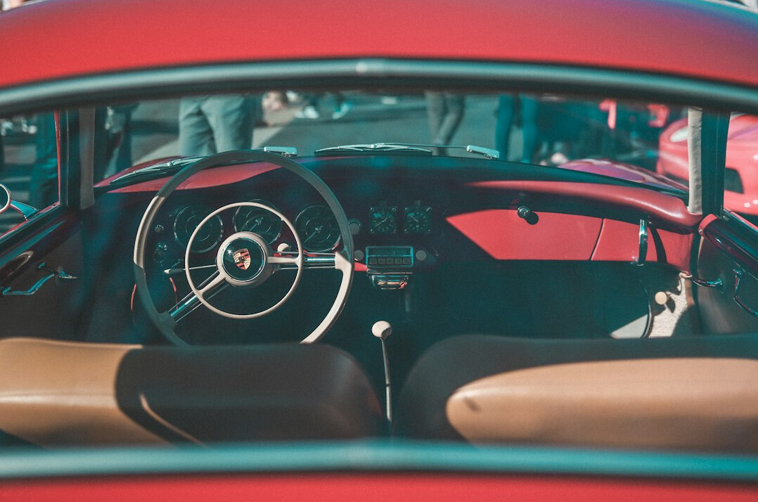 Driver's view of a vintage car dashboard and steering wheel