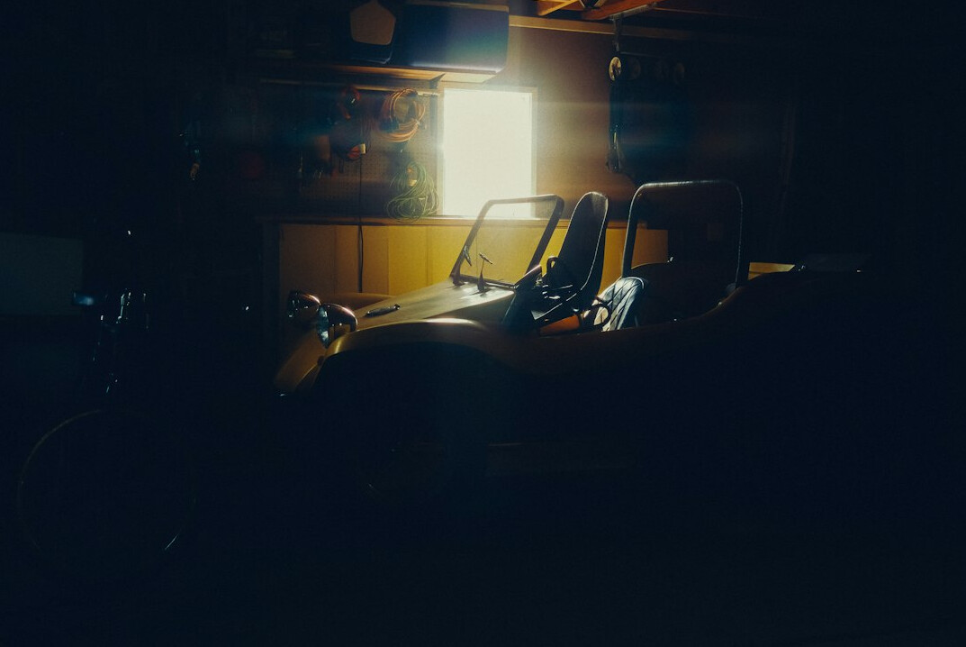 Close up of a vintage steering wheel inside a dark garage